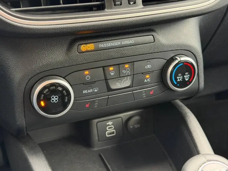Détail de la console centrale du Ford Kuga 2024, montrant les commandes de climatisation et les ports USB.