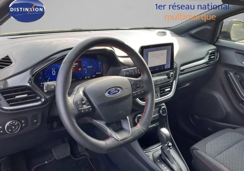 Intérieur de la Ford Puma 2023, vue côté conducteur sur le tableau de bord noir avec volant multifonction et écran tactile central.