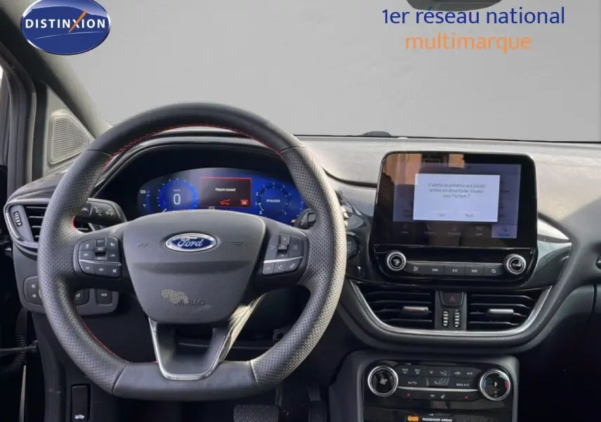 Vue intérieure du tableau de bord et volant du Ford Puma noir agate métal, avec écran tactile central allumé.