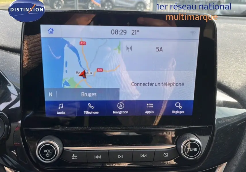 Écran tactile central du Ford Puma 2023 affichant la navigation avec carte et options multimédia, entouré de commandes noires brillantes.