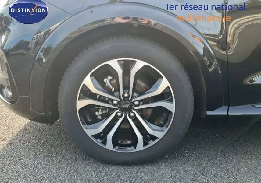 Gros plan sur la roue avant gauche d’un Ford Puma noir Agate Metal avec jante alliage bicolore.
