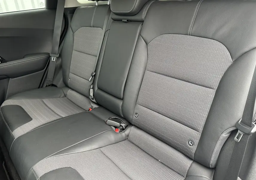 Vue rapprochée des sièges arrière en tissu gris et cuir noir du Kia Niro hybride rechargeable blanc céleste 2020.