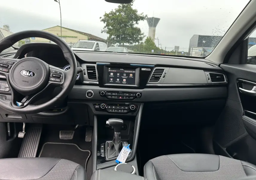 Intérieur noir du Kia Niro hybride rechargeable 2020 vu de face, avec tableau de bord et écran tactile central.