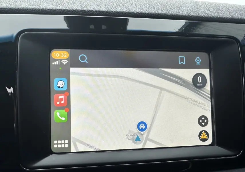 Écran tactile du système de navigation du Kia Niro hybride rechargeable, affichant une carte et des icônes d'applications.