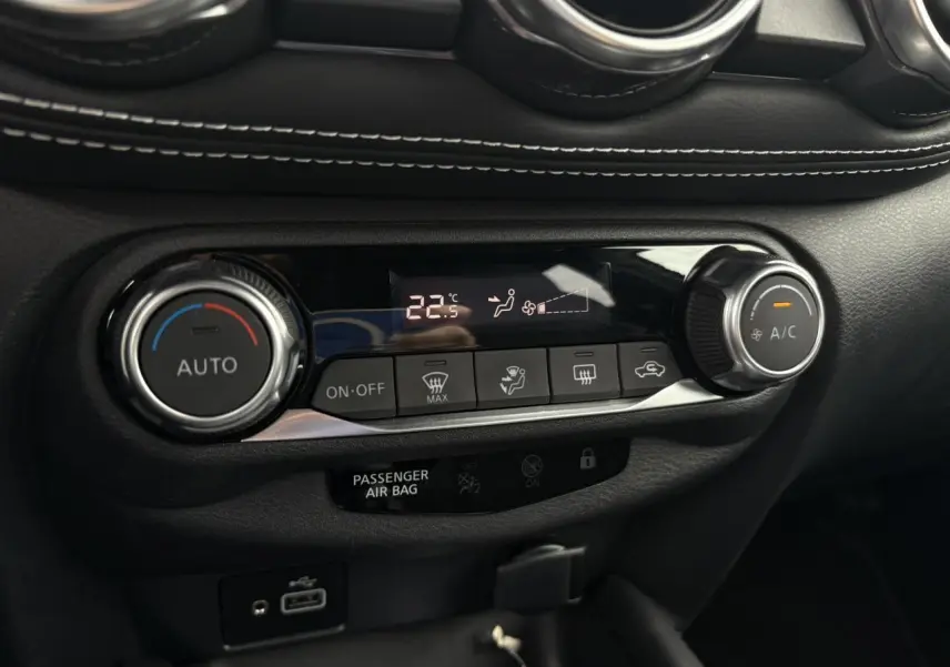 Gros plan sur la commande de climatisation automatique du Nissan Juke blanc perle 2023 avec affichage digital à 22,5°C.