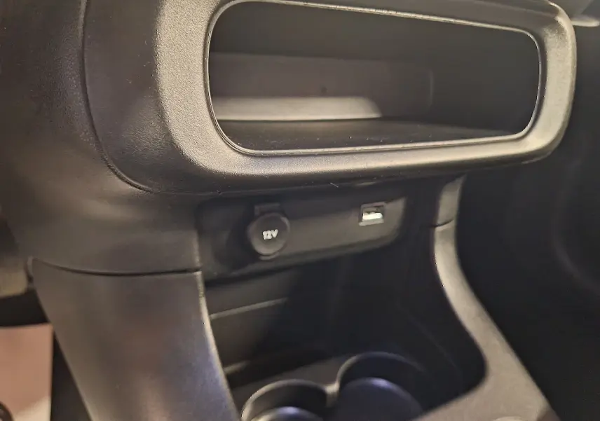 Prise 12V et port USB en gros plan dans la console centrale noire de la Citroën C3 gris 2019 finition Shine.