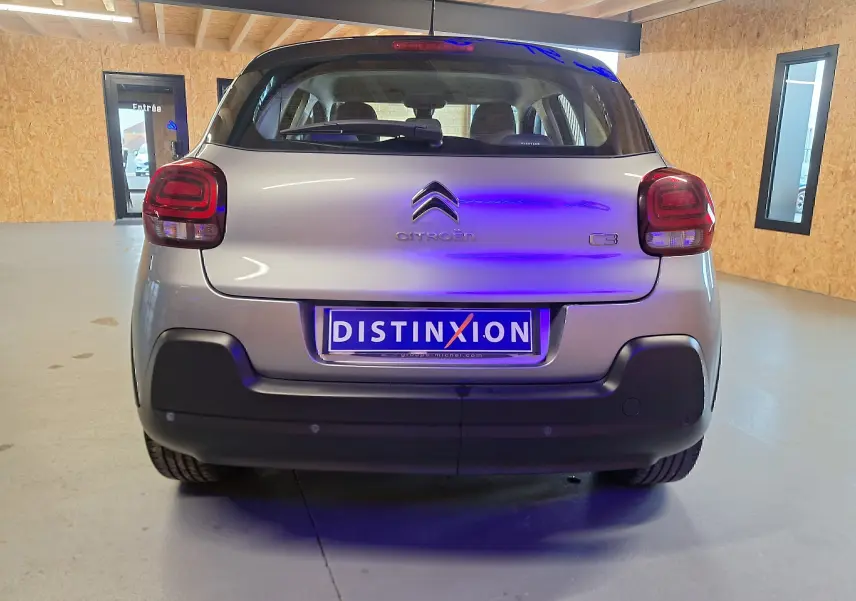 Vue arrière d'une Citroën C3 gris clair 2019 avec feux arrière arrondis et plaque Distinxion.