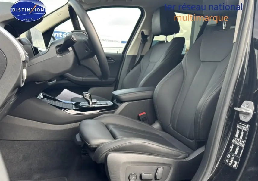 Intérieur avant droit du BMW X3 noir 2024, sièges sport en similicuir noir avec console centrale et volant cuir.