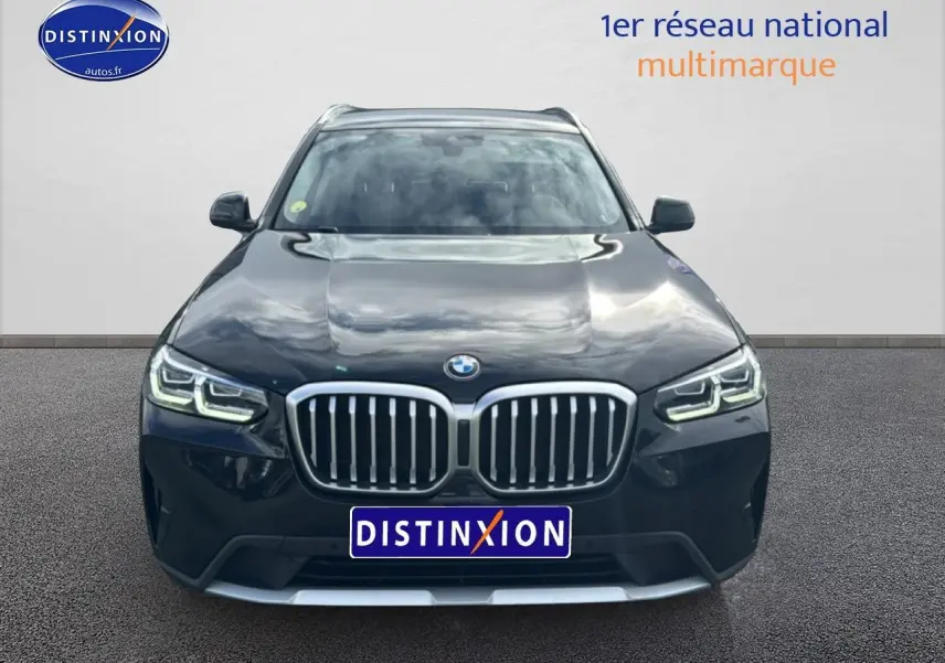 Vue frontale d'un BMW X3 noir 2024 avec calandre double haricot et phares LED allumés.