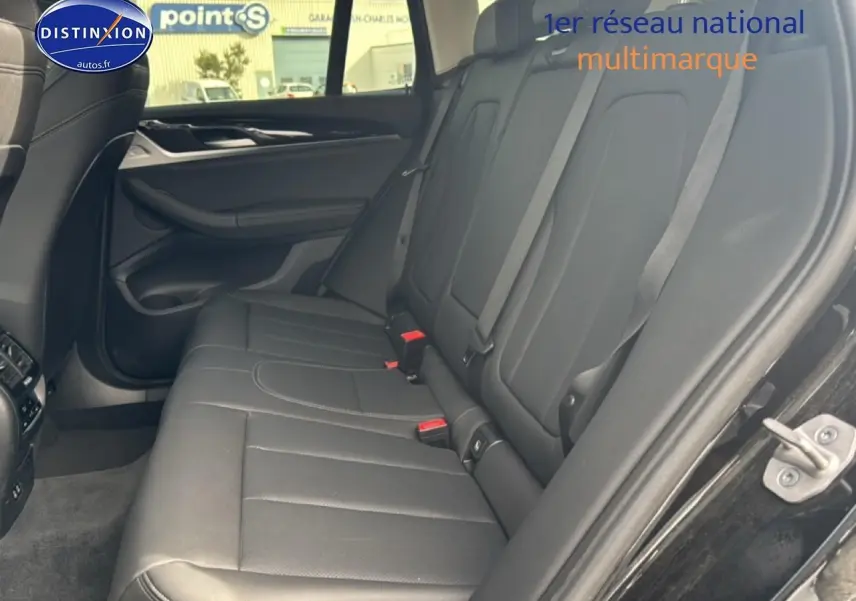 Vue intérieure côté droit des sièges arrière en similicuir noir du BMW X3 G01 xdrive20d 2024 avec ceintures grises.