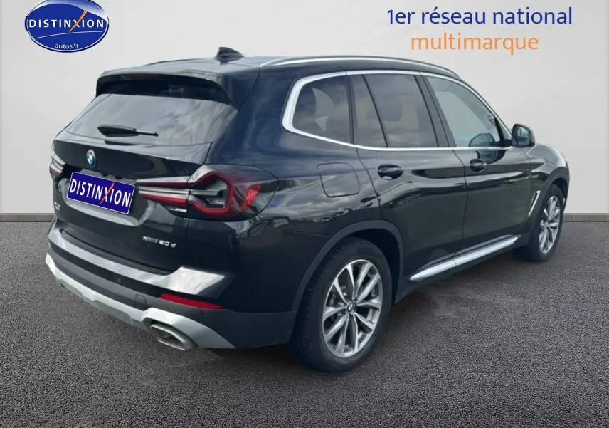 BMW X3 xDrive20d noir vue 3/4 arrière droit avec jantes alu et sorties d'échappement chromées