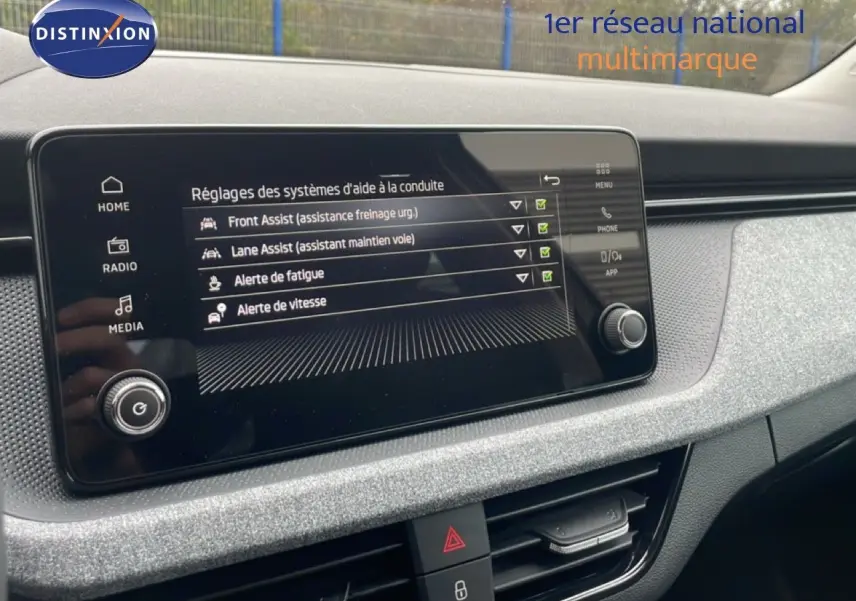 Écran central du tableau de bord du Skoda Kamiq 2025 montrant les réglages d'aides à la conduite, ambiance intérieure grise.