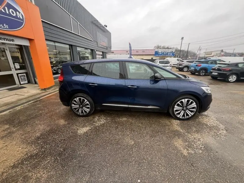 Renault Grand Scenic bleu Cosmos vu de profil côté gauche, avec jantes alliage et vitres surteintées.