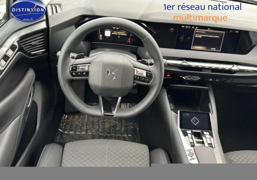 Vue intérieure centrée sur le volant cuir et tableau de bord numérique du DS4 Hybride 145 gris platinium 2024.