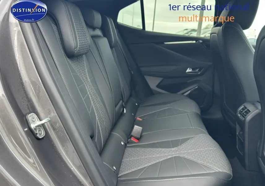 Vue intérieure côté gauche des sièges arrière en cuir gris du DS4 Hybride 145 Pallas 2024 avec accoudoirs et finitions soignées.