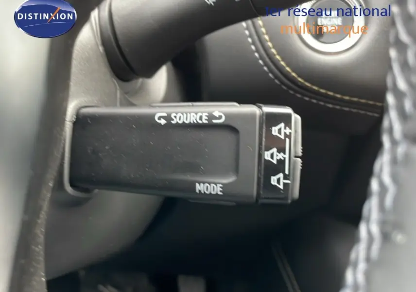 Gros plan sur la commande au volant du Renault Symbioz bleu iron metal, avec boutons source et mode visibles.