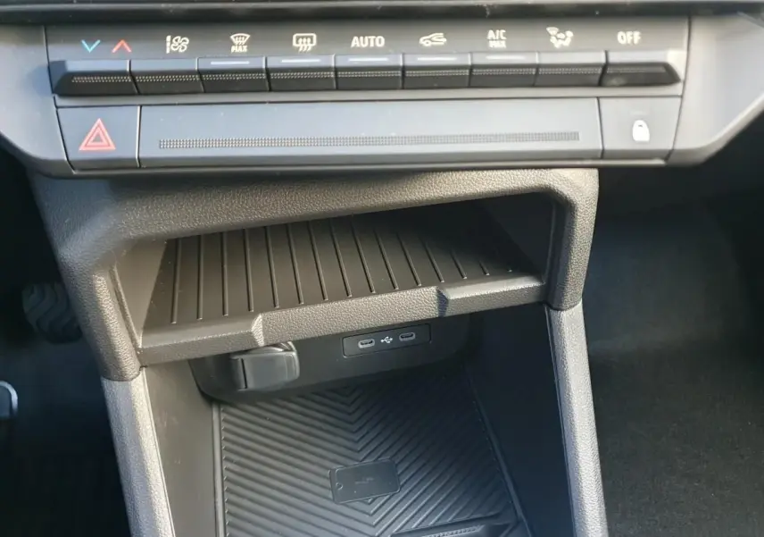 Vue rapprochée de la console centrale du Dacia Duster 2026, montrant les commandes climatisation et deux prises USB type C.