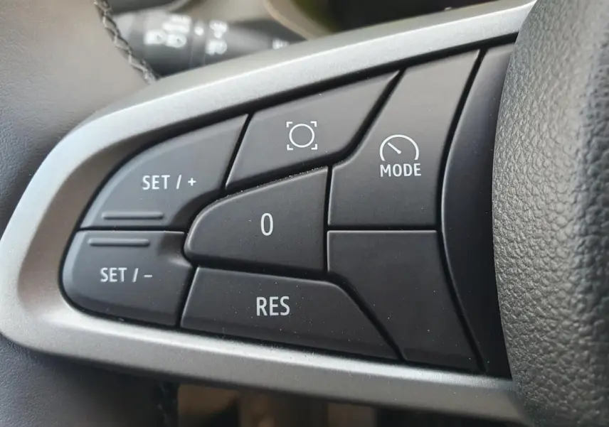 Gros plan sur les commandes au volant du Dacia Duster 2026, finition Journey, avec boutons de régulateur de vitesse.