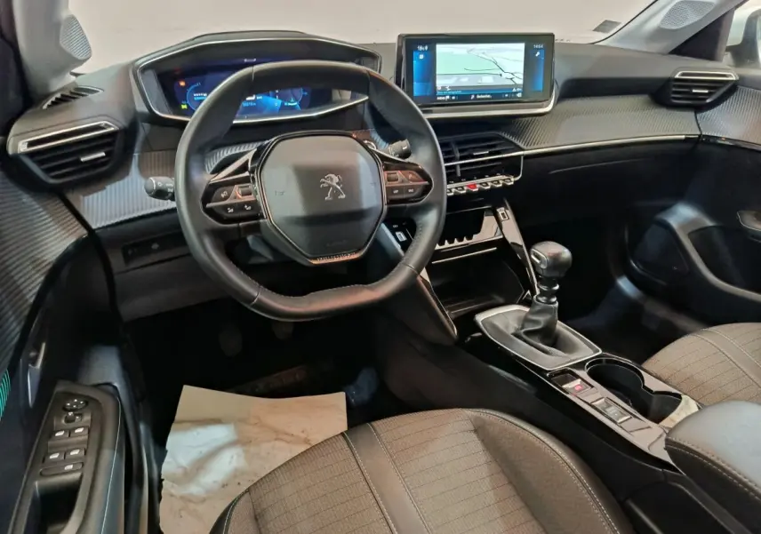 Intérieur Peugeot 208 PureTech 100 vue côté conducteur, volant cuir, écran tactile 10 pouces et boîte manuelle.