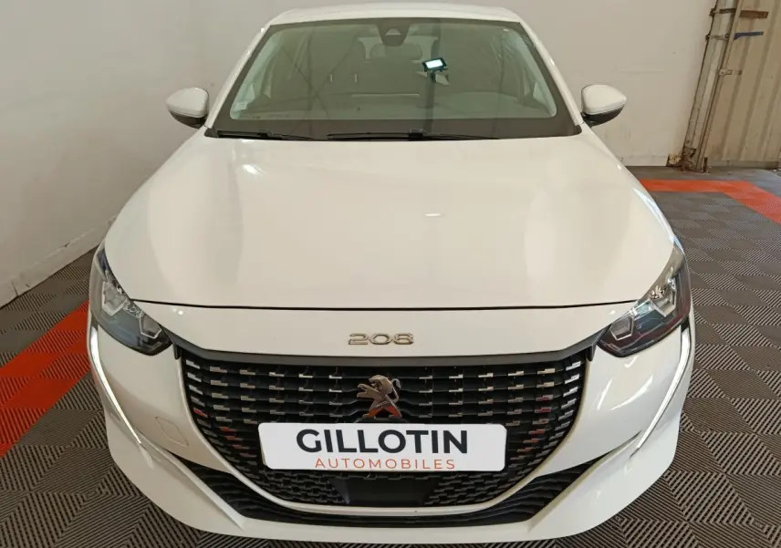 Vue avant d'une Peugeot 208 blanche, mettant en valeur sa calandre noire et ses phares LED distinctifs.