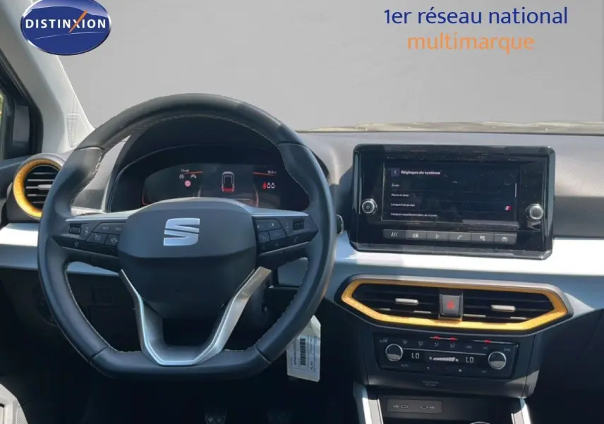 Vue intérieure centrée sur le volant et le tableau de bord du SEAT Arona 2025 avec détails jaunes autour des aérateurs.