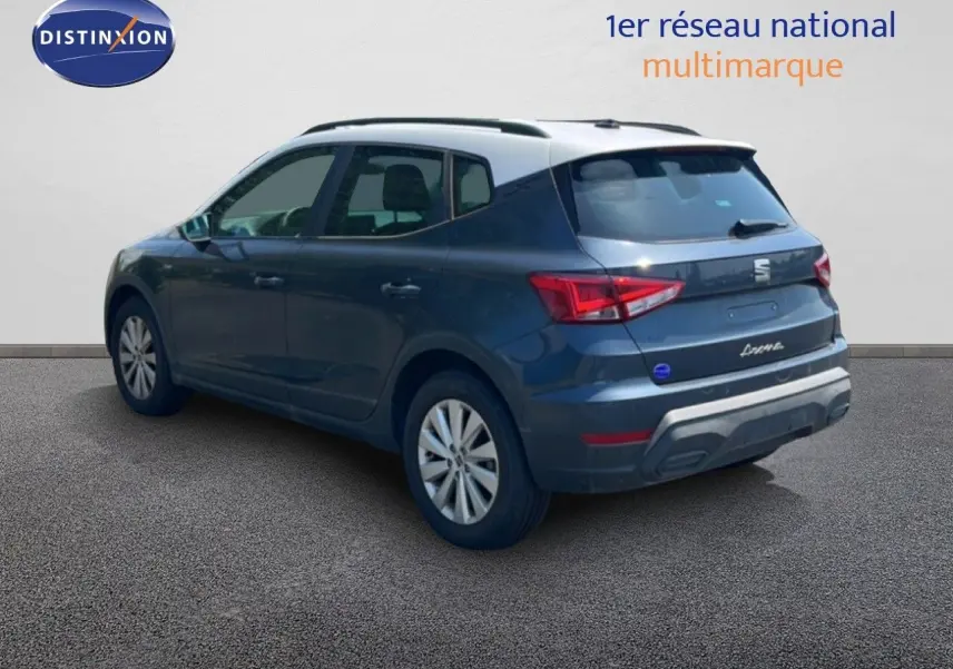 Vue 3/4 arrière droite d’un SEAT Arona gris Magnetic avec toit blanc, sur fond neutre intérieur.