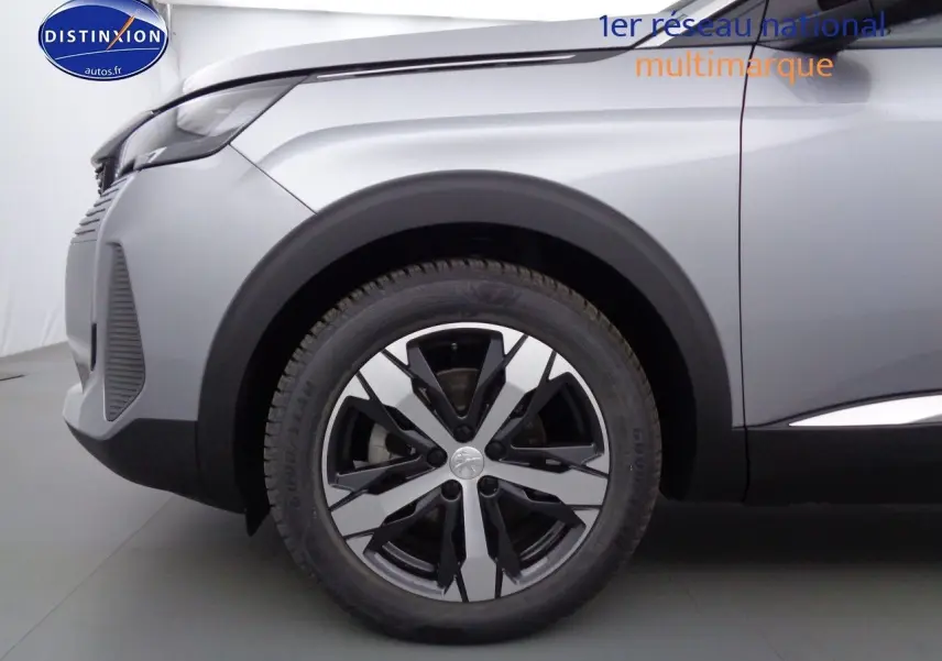 Gros plan sur la roue avant gauche du Peugeot 3008 gris Artense métal, soulignant la jante bi-ton moderne.