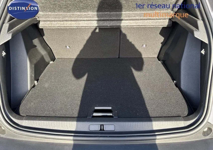 Coffre ouvert vu de l'arrière d'un Peugeot 2008 gris Artense, montrant un espace de chargement propre et spacieux.