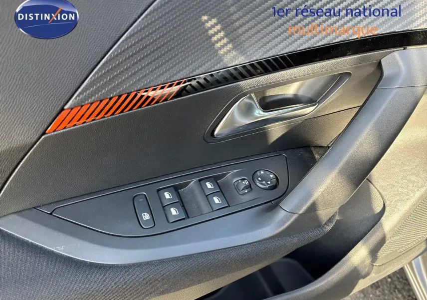 Détail de la porte côté conducteur du Peugeot 2008 gris Artense, montrant les commandes des vitres et le design intérieur.