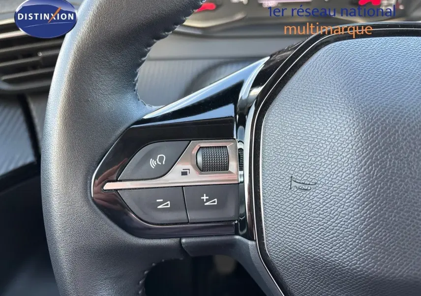 Gros plan sur les commandes gauche du volant en cuir noir du Peugeot 2008 gris Artense, version 1.2 PureTech 130 Active 2021.