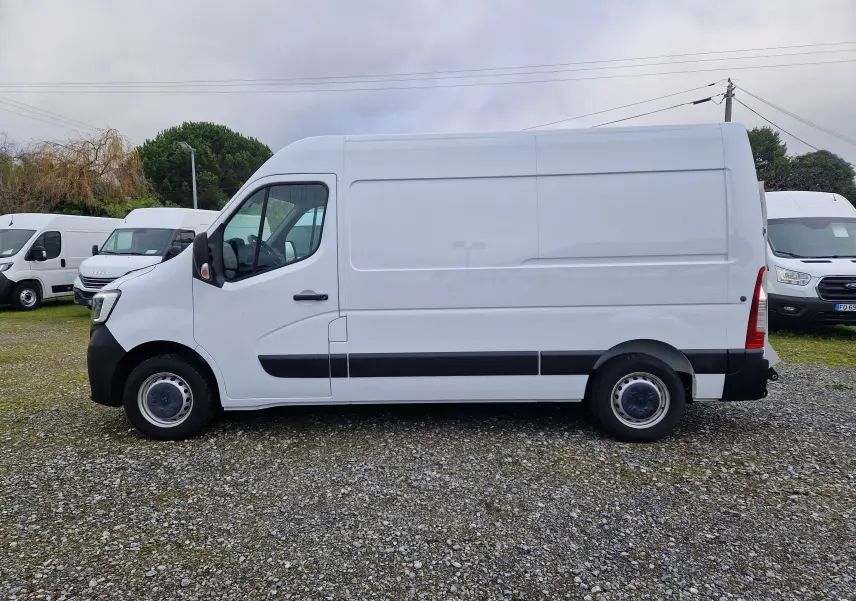 Profil latéral gauche d’un utilitaire Renault Master blanc L2H2 3T3 avec hayon, stationné sur un sol gravillonné.