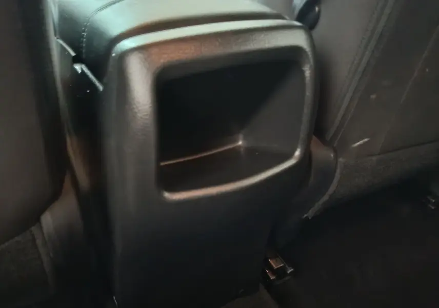 Détail intérieur montrant le rangement central arrière en plastique noir du Nissan Qashqai gris clair 2019.