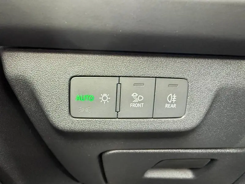Gros plan sur les commandes d’éclairage automatique et antibrouillard avant et arrière dans un Audi Q3 noir Mythique métallisé.