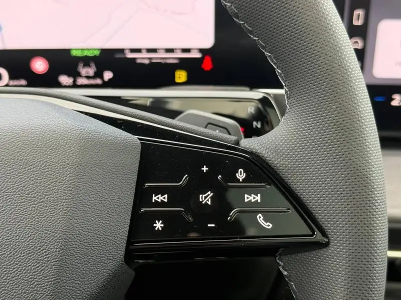 Gros plan sur les commandes tactiles du volant côté droit de l'Audi Q3 2026 avec finition S line en Noir Mythique métallisé.
