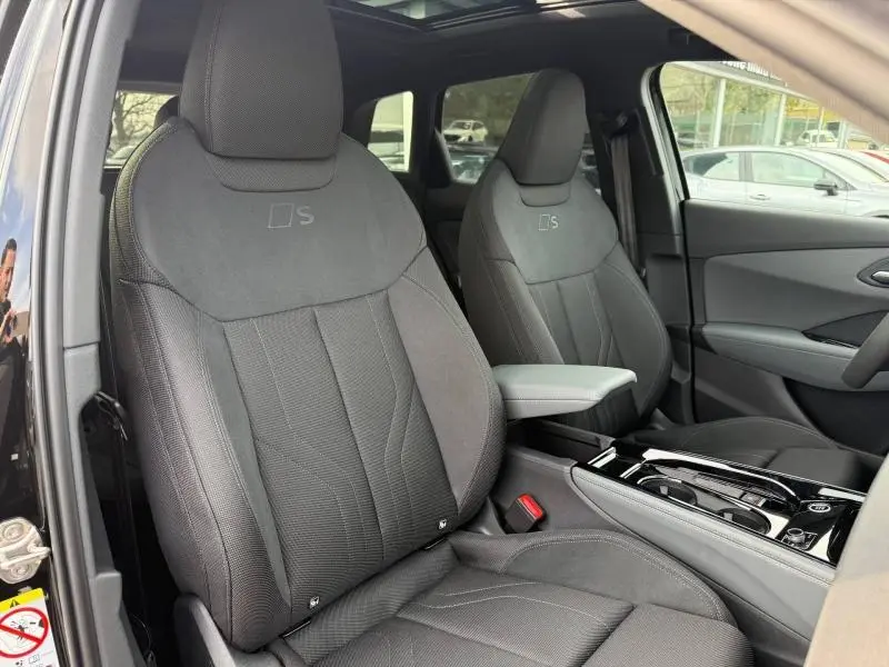 Vue intérieure des sièges avant noirs S line du Audi Q3 2.0 TDI 150ch 2026 avec console centrale et toit ouvrant.