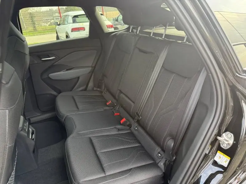 Vue intérieure côté droit des sièges arrière en tissu noir du SUV Audi Q3 2026 finition S line, porte ouverte.