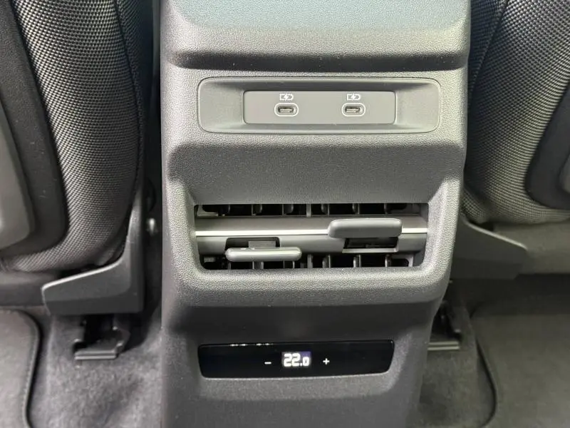 Vue rapprochée de la console arrière noire avec prises USB-C, aérateurs et réglage de la climatisation à 22°C dans un Audi Q3.