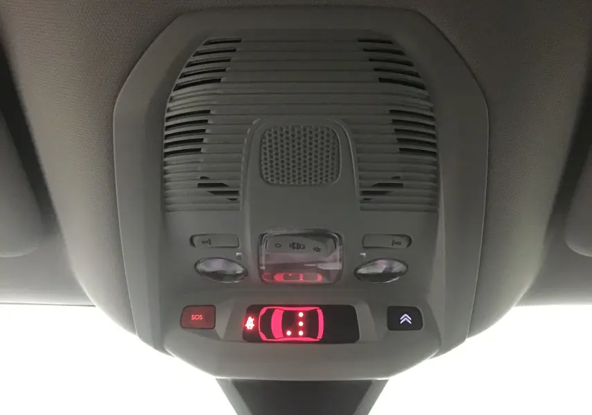 Vue rapprochée du plafonnier intérieur du Citroën C5 Aircross gris, avec boutons d'éclairage et alerte SOS allumée.