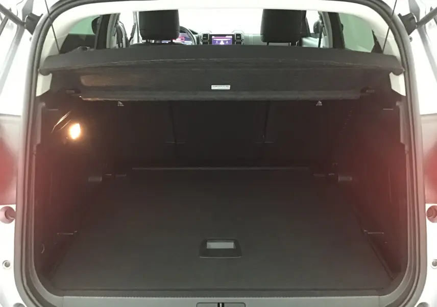 Coffre ouvert d'un Citroën C5 Aircross gris Artense vu de l'arrière, montrant l'espace de chargement vide et la tablette cache-bagages.