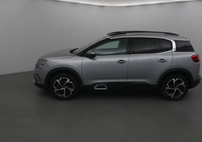 Profil côté gauche du Citroën C5 Aircross gris Artense 2021 avec jantes alliage et barres de toit noires.
