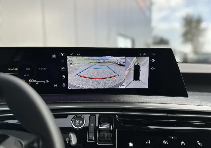 Vue intérieure du tableau de bord du Peugeot 3008 Hybrid gris Artense, écran panoramique affichant caméra 360° et aide au stationnement.