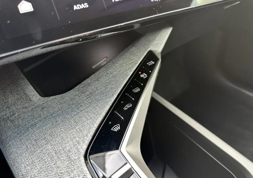 Gros plan sur la console centrale tissu gris avec commandes tactiles et écran panoramique du Peugeot 3008 Hybrid 145 Allure 2025.