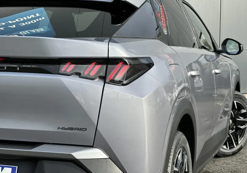 Vue 3/4 arrière droit du Peugeot 3008 Hybrid gris Artense avec feux arrière LED à 3 griffes et jantes alliage noires.