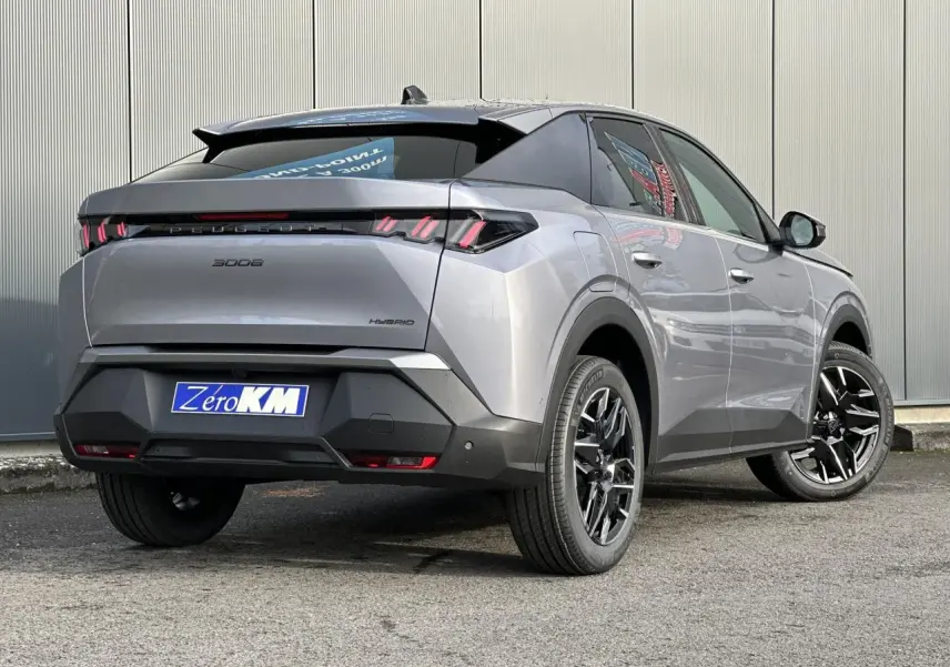Vue 3/4 arrière droite d’un Peugeot 3008 Hybrid gris Artense avec feux arrière à LED en forme de griffes et jantes alliage noires.
