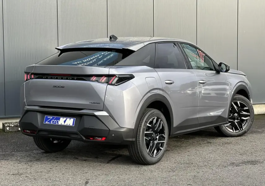 Vue 3/4 arrière droit d'un Peugeot 3008 Hybrid gris Artense avec jantes alliage noires et feux arrière LED 3 griffes.