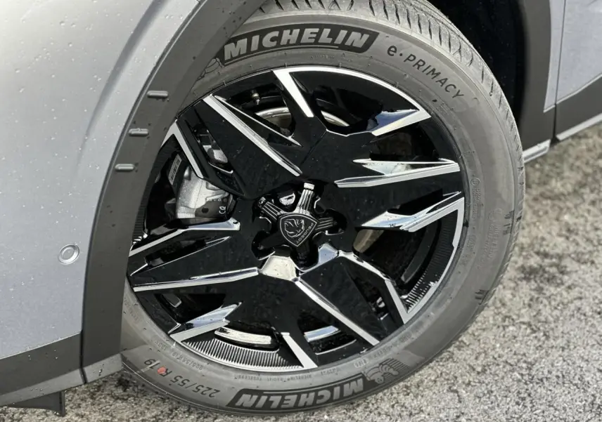 Gros plan sur la jante alliage noire diamantée 19'' avec pneu Michelin, côté arrière droit du Peugeot 3008 gris Artense.