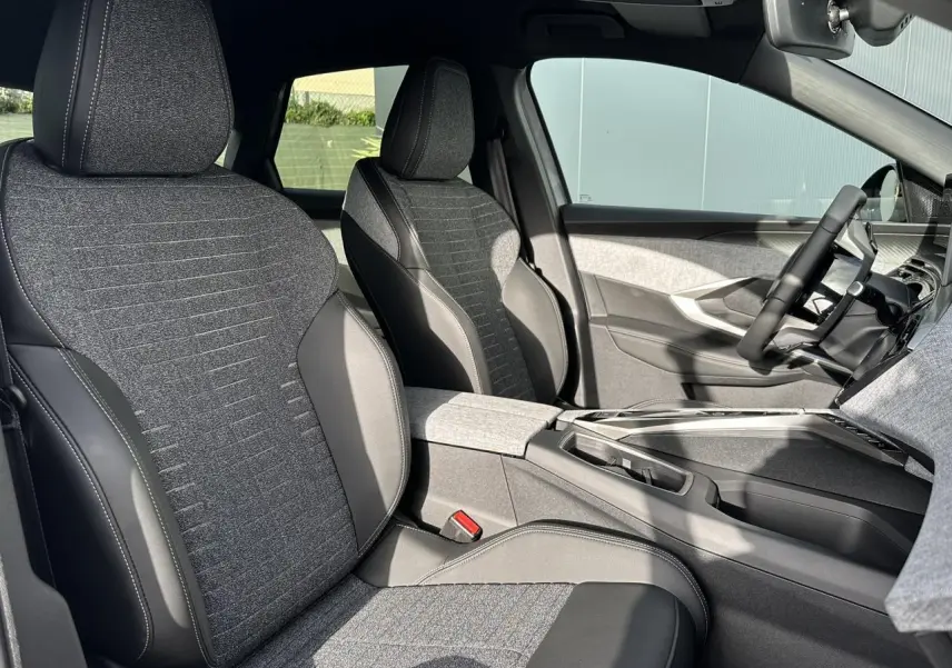 Vue intérieure côté droit des sièges avant gris tissu et cuir du Peugeot 3008 Hybrid 145 Allure avec console centrale moderne.