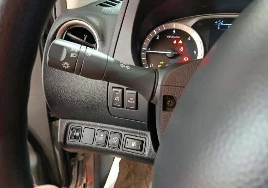 Vue rapprochée du tableau de bord côté gauche du Nissan Navara gris clair, montrant commandes et compte-tours.