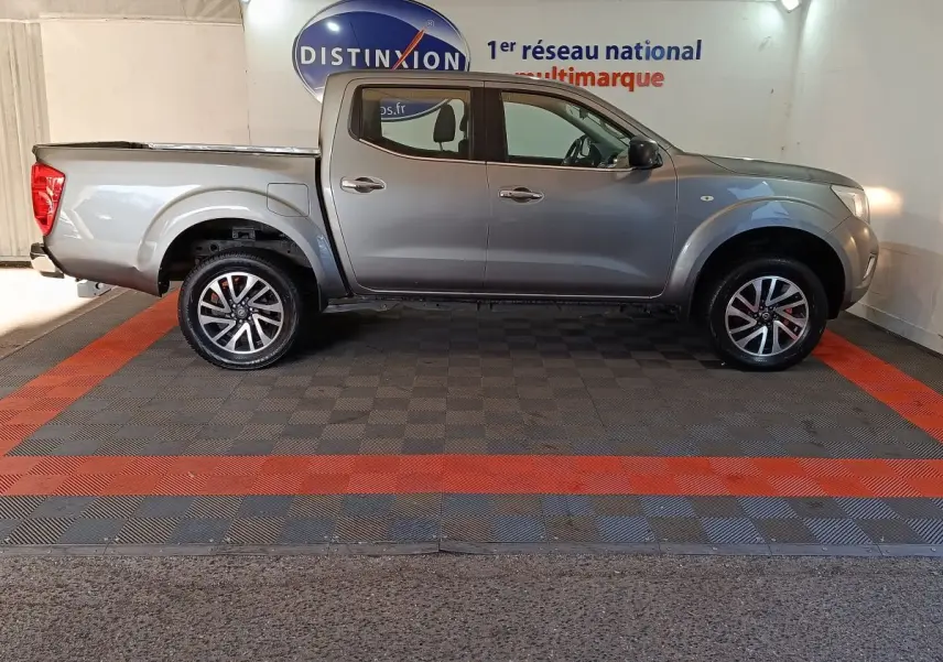 Vue de profil droit du pick-up Nissan Navara gris clair Double-Cab 2018, avec jantes alliage et benne couverte.