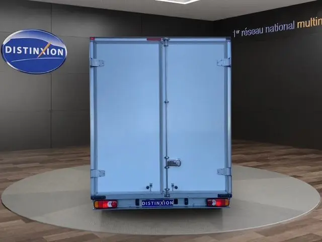 Vue arrière d’un Renault Master blanc 2022 avec caisse fermée, présenté en intérieur sur plateforme circulaire.